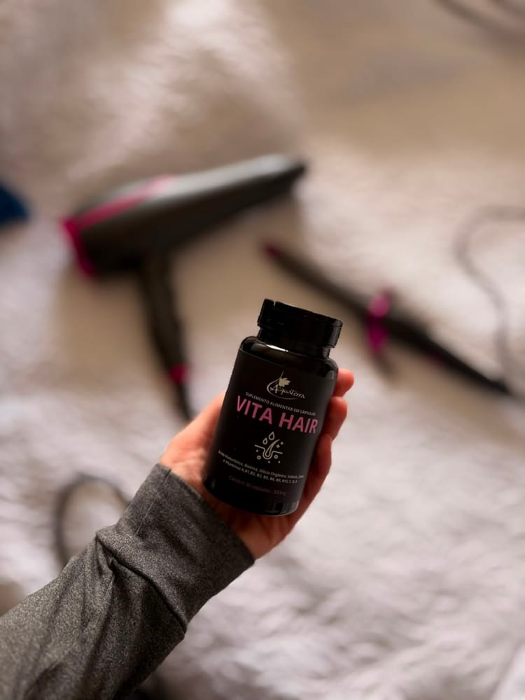 Rótulo do Vita Hair com a lista de ingredientes, segurado na mão.